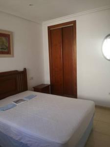 ein Schlafzimmer mit einem Bett in einem weißen Zimmer in der Unterkunft Torremar vera playa naturista in Vera