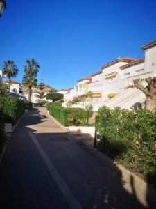 een lege straat met gebouwen en bomen aan de zijkant bij Torremar vera playa naturista in Vera