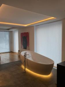 uma grande banheira branca num quarto com janelas em Pezza 21 em Samnaun