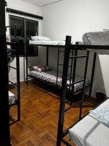 Habitación con 3 literas y suelo de madera. en Center Hostel Sp, en São Paulo