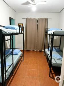 a room with three bunk beds and a wooden floor at Center Hostel Sp in São Paulo