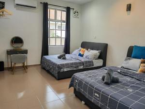 a bedroom with two beds with stuffed animals on them at Cozy Roomstay Padang Serai in Padang Serai