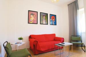 ローマにあるHH Vatica Suite IIの赤いソファ付きのリビングルーム、壁に絵画