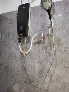 a shower with a hair dryer and a blow dryer at Cozy Roomstay Padang Serai in Padang Serai