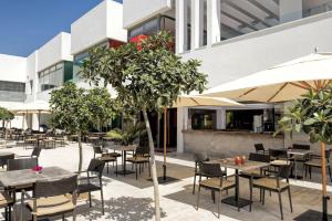 an outdoor restaurant with tables and chairs and umbrellas at Iberostar Selection Diar El Andalous in Port El Kantaoui