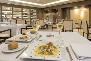 a table with two plates of food and glasses of wine at Iberostar Selection Diar El Andalous in Port El Kantaoui