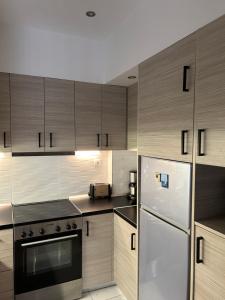 a kitchen with stainless steel appliances and wooden cabinets at Athens Acropolis cozy apartment in Athens