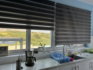 a kitchen with a window with blinds over a sink at Villa Maïa in Dhrámia
