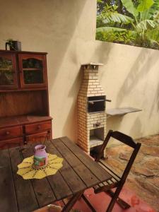 una mesa de madera con un horno de ladrillo en una habitación en Casa Jasmim, en Cavalcante