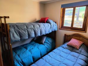 a bedroom with two bunk beds and a window at Casa Bella Vista Futrono in Futrono
