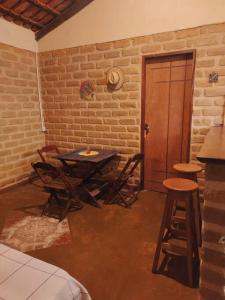 Habitación con mesa, sillas y puerta en Casa Jasmim en Cavalcante