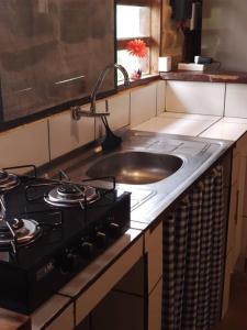 a kitchen counter with a sink and a stove at Casa Jasmim in Cavalcante