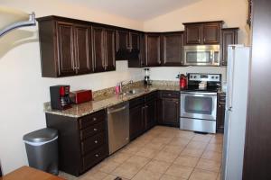 a kitchen with wooden cabinets and a stove top oven at House # 49 No Wake Zone (no pets) in Centre