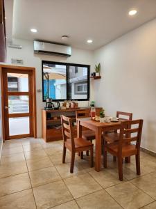 - une salle à manger avec une table et des chaises en bois dans l'établissement CASA GALAPAGOS by Hostal Fragata, à Puerto Ayora