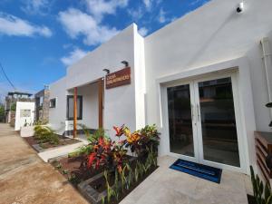 a white building with a sign for a restaurant at CASA GALAPAGOS by Hostal Fragata in Puerto Ayora