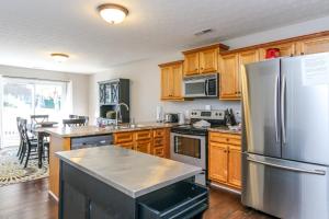 a kitchen with wooden cabinets and a stainless steel refrigerator at House #53 Flip Flop Inn (no pets) in Centre