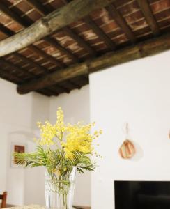 een vaas gevuld met gele bloemen zittend op een tafel bij Casa Refúgio in Évora