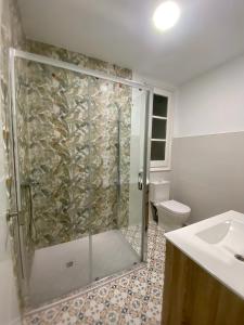 a bathroom with a shower with a toilet and a sink at Central Rooms & Suites at Bruno Valencia Apartments Downtown in Valencia