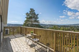 a wooden deck with a table and chairs on it at Luxury house with 5 bedrooms close to Oslo Centrum in Lorenskog