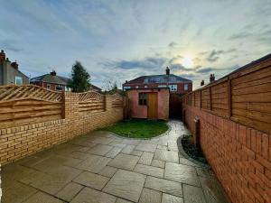 a backyard with a fence and a house at Freeston House - Charm Townhouse in Cleethorpes