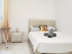 a white bedroom with a bed with a teddy bear on it at Homestay Pangsapuri Simfoni 3BR 7Pax Kuah Langkawi in Kuah