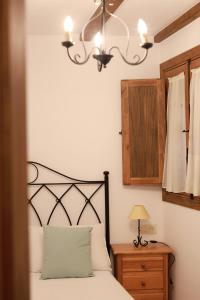 a bedroom with a bed with a lamp and a dresser at Casa rural La Aldea in Cabezuela del Valle