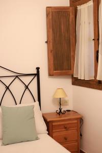 a bedroom with a bed and a table with a lamp at Casa rural La Aldea in Cabezuela del Valle