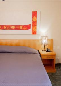 - une chambre avec un lit et une table avec une lampe dans l'établissement Beira mar Flat 2-209, à Ilhabela