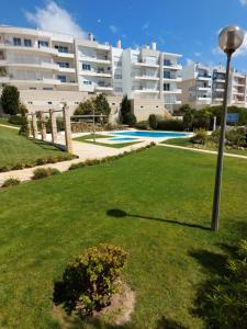 a large apartment building with a yard with a swimming pool at See to Sea in Ericeira