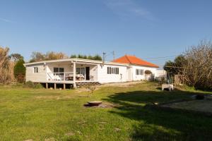 a small white house in a yard with a yard at Quinta da Cris (Private Beach Retreat) in Costa Nova