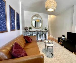 a living room with a brown couch and a mirror at Make your Nashville trip perfect in Nashville