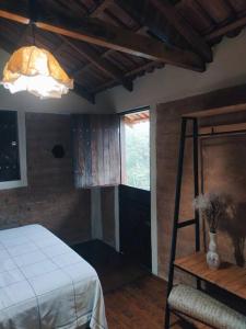 a bedroom with a bed and a ladder and a light at Rosa dos Ventos Chalés in Cavalcante