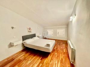 1 dormitorio con 1 cama y suelo de madera en Barco, en Toledo