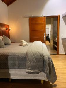 a bedroom with a bed with a stuffed animal on it at Apartamento Avenida in Camanducaia
