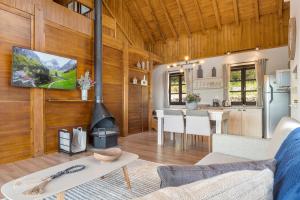 ein Wohnzimmer mit Holzwänden und eine Küche mit Kamin in der Unterkunft Cabana Rote Hütte Vila Germânica by Achei in Nova Petrópolis