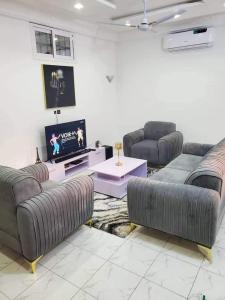 uma sala de estar com sofás e uma televisão de ecrã plano em Timba chic-Allada em Allada