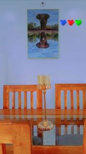 una mesa de cristal con una lámpara y una foto en la pared en Timba chic-Allada, en Allada