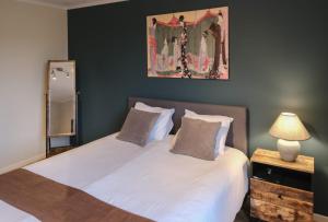 a bedroom with two beds and a picture on the wall at Guesthouse Orchid in Bruges