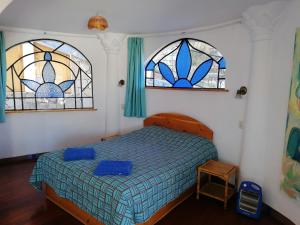a bedroom with a bed and two stained glass windows at Suites Sultan in Copacabana