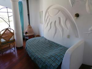a bedroom with a bed and a chair in a room at Suites Sultan in Copacabana
