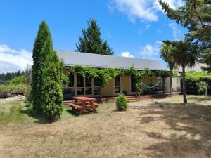 een huis met een picknicktafel in de tuin bij Vibrant Living Retreat in Hanmer Springs