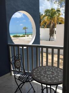 d'une table et d'une chaise sur un balcon avec vue sur la plage. dans l'établissement Coco’s Beach, à Sisal