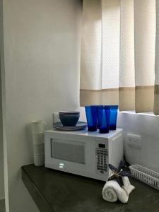 un four micro-ondes assis sur un comptoir avec des lunettes bleues dans l'établissement Coco’s Beach, à Sisal