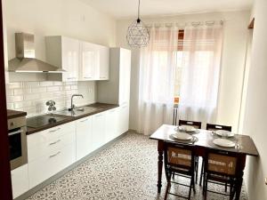 a kitchen with a table and chairs and a sink at Casa Marconi - City Center in Bra