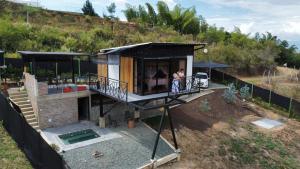 zwei Personen stehen auf dem Balkon eines Hauses in der Unterkunft Cabaña Macareo in Tuluá