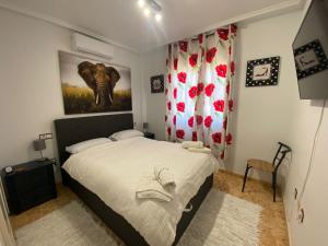 - une chambre avec un lit et une peinture d'éléphant dans l'établissement Saint James park 2 dormitorios, à Orihuela