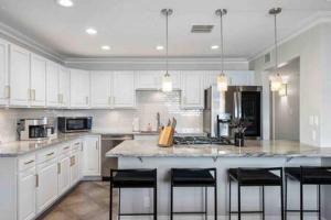 a kitchen with white cabinets and a island with bar stools at Desert Oasis Family Retreat Old Town Scottsdale in Scottsdale