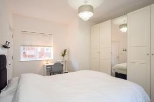 a white bedroom with a white bed and a desk at Watford Central Serviced Apartments 2 in Watford