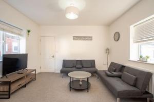 a living room with a couch and a tv at Watford Central Serviced Apartments 2 in Watford