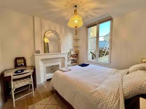 - une chambre avec un lit, une cheminée et un lustre dans l'établissement Cosy appartement Bordeaux centre, à Bordeaux